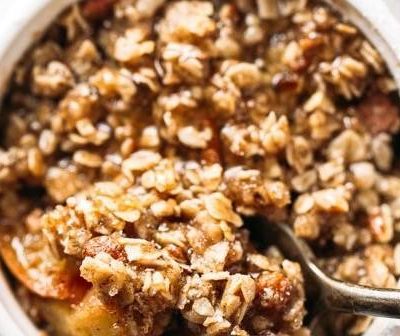 Coconut Oil Apple Crisp in a pan with a wooden spoon.