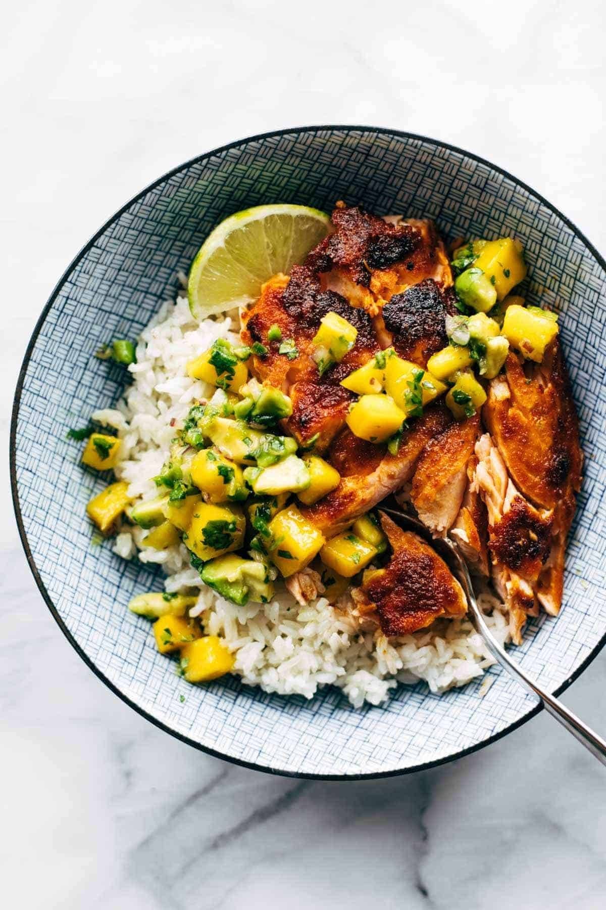Salmon in a bowl with rice and mango salsa.