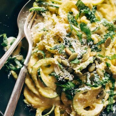 Creamy Corn Zoodles in a bowl with fork and spoon.