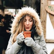 Lindsay holding a mug of mulled wine.