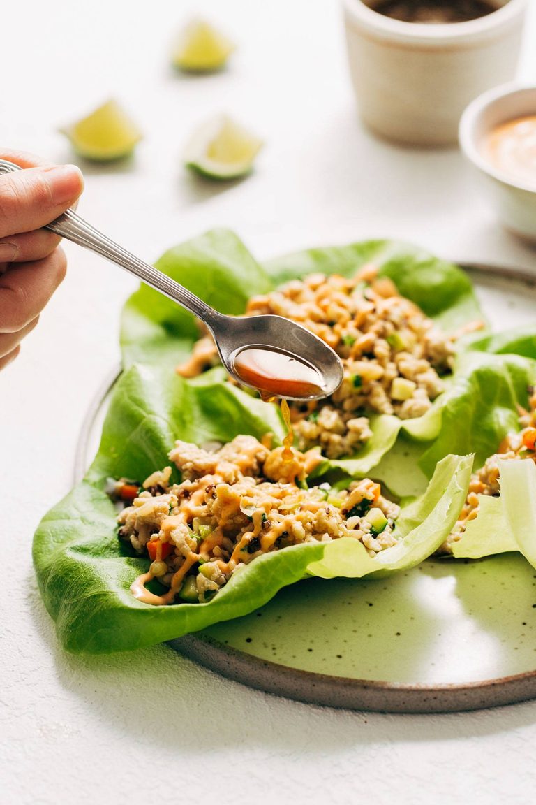 Chicken lettuce wraps with lime sauce poured on top.