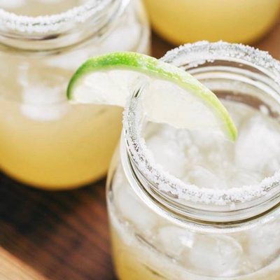 Margaritas for a Crowd in mason jars with lime.