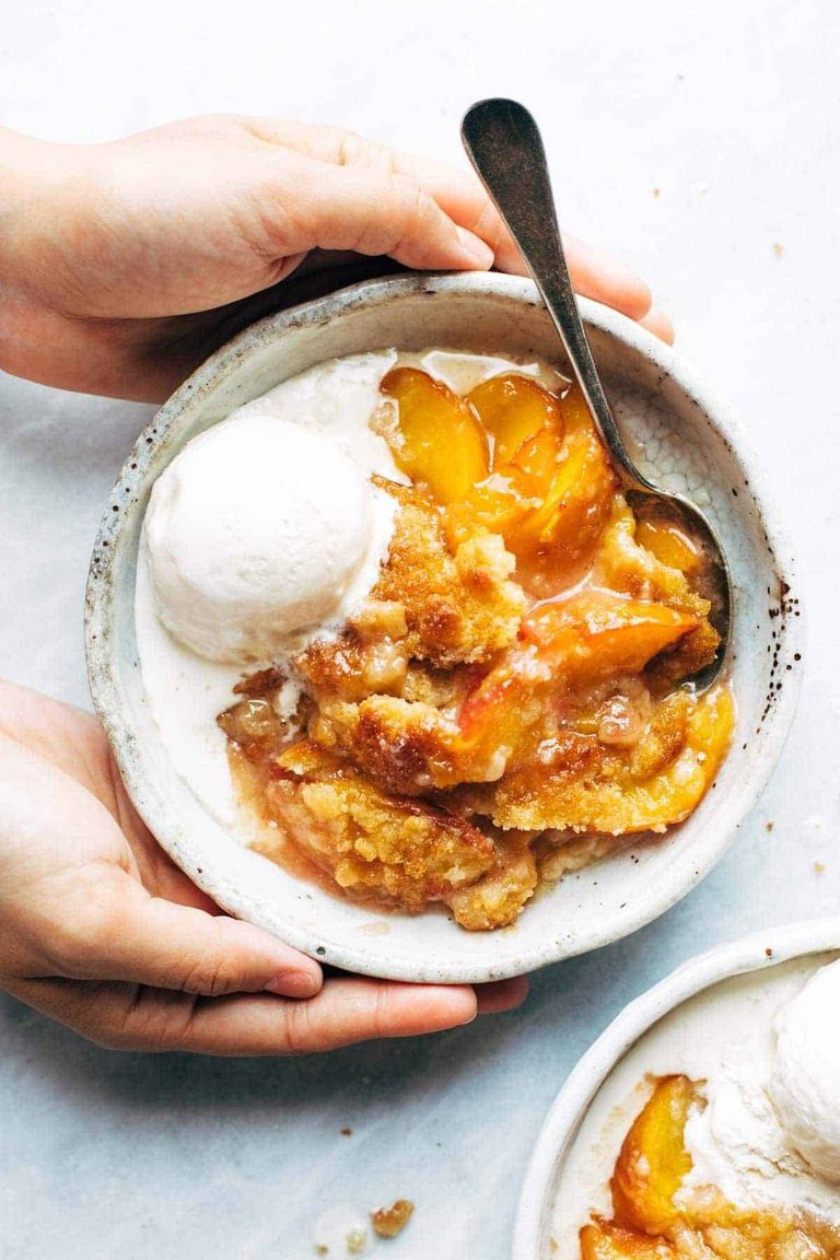 Peach cobbler on a plate with ice cream.