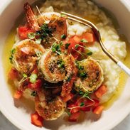 Pesto shrimp with risotto and a fork in a bowl