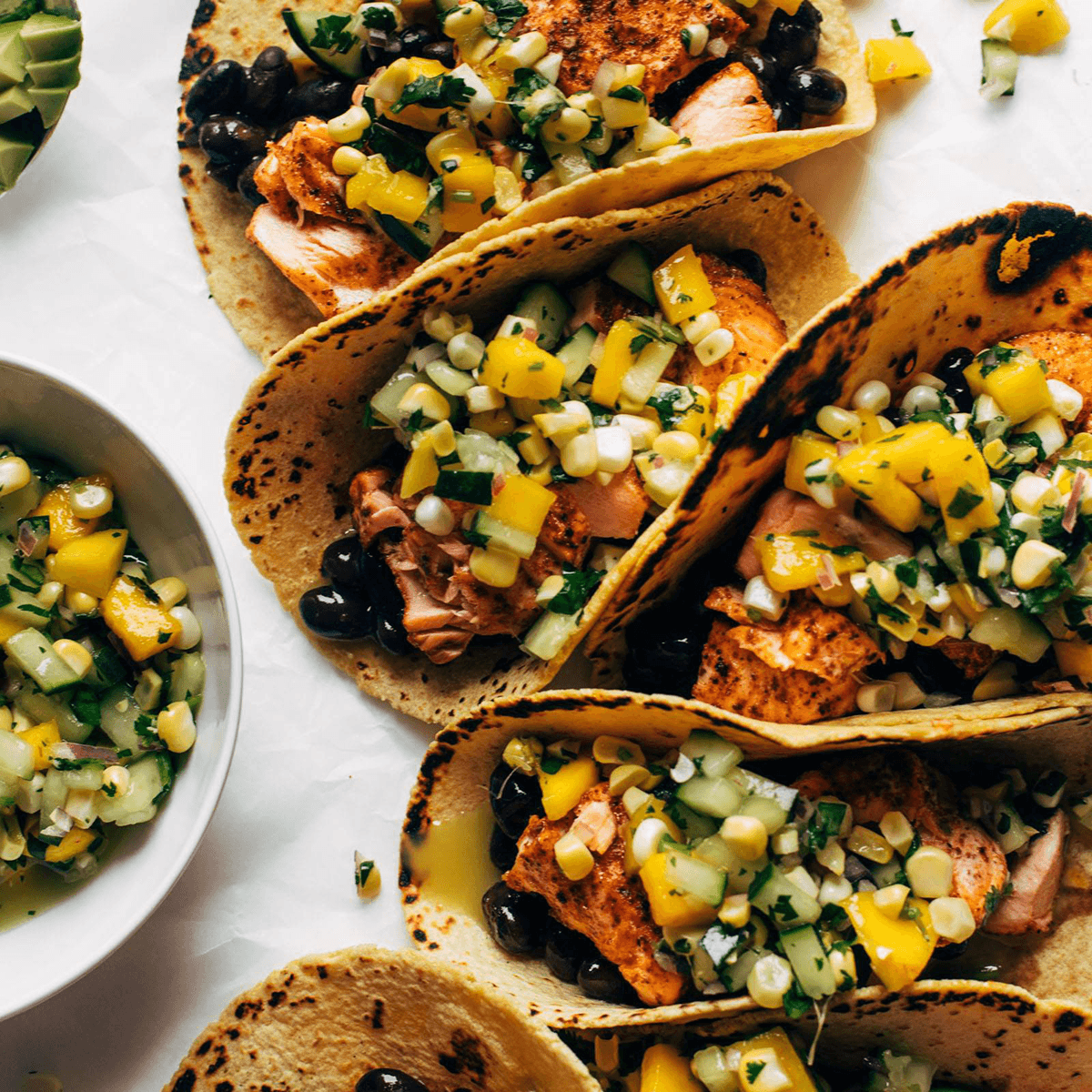 Salmon tacos with salsa on top.