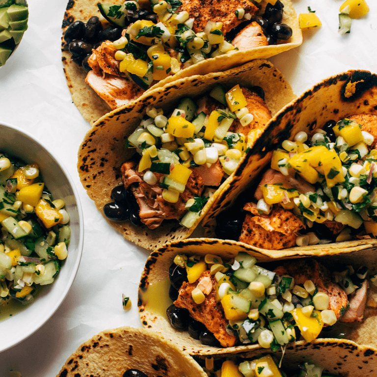 Salmon tacos with salsa on top.