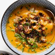 Sweet potato soup in a bowl topped with cauliflower crumbles.