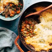 Meatless shepherd's pie being spooned out of a red pot.