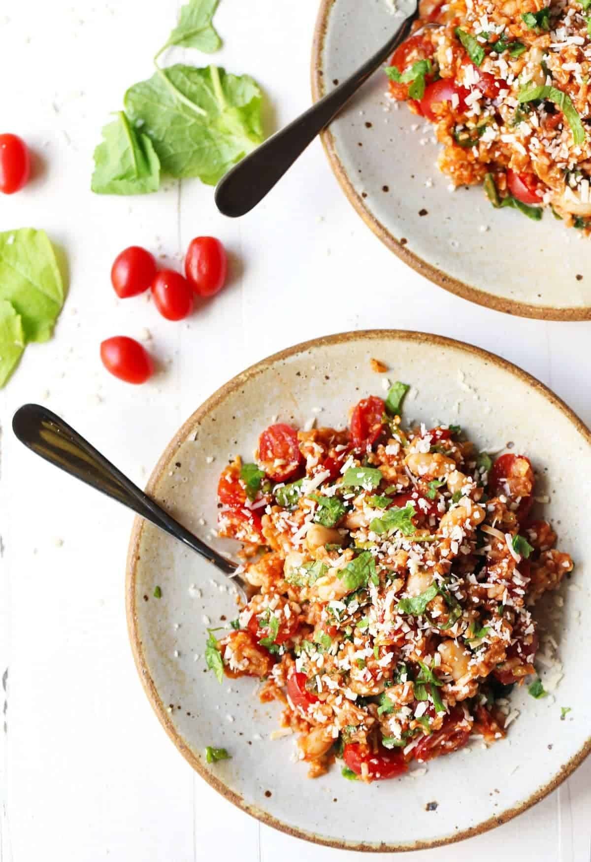 Asiago White Beans with Farro, Kale, and Tomatoes on plates with forks.